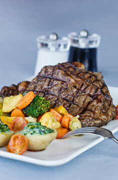 Grilled steak with roasted vegetables and creamed spinach potatoes on plate