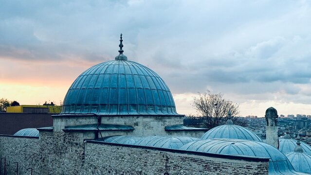 Majestic view of the main stone dome of Suleymaniye Mosque against a beautiful sunset sky in Istanbul, Turkey. Ancient Ottoman architecture, urban travel landscape and twilight tourism concept.