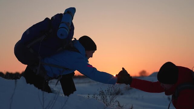 Achieve your goal. Business team victory. Travelers conquer mountain together. Climbers, holding hands, reach top of hill. Silhouettes. Business people working team. Lend helping hand, partner