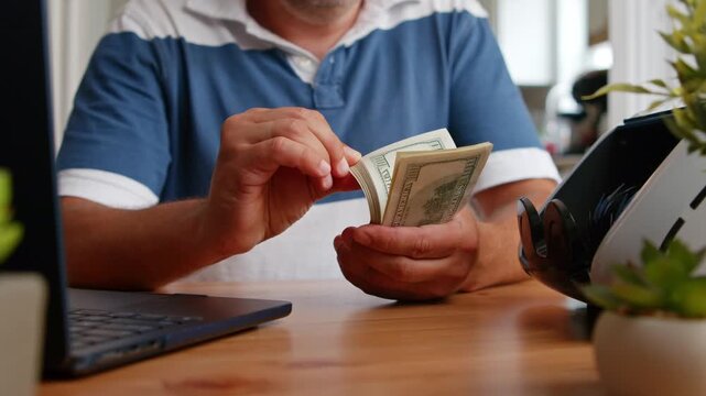 Hands carefully sort through stacks of cash in a bright, inviting office space. The process is both focused and thoughtful, showcasing the significance of financial awareness