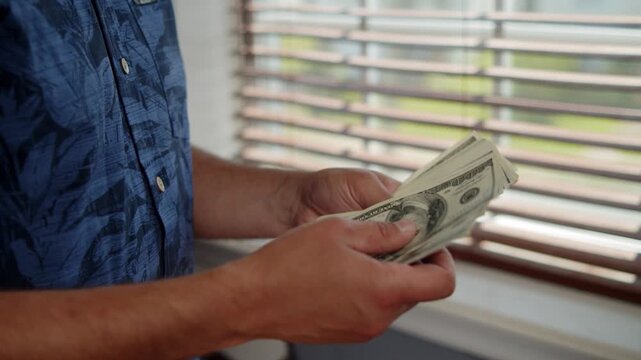 Hands skillfully sort through crisp dollar bills, catching warm rays of afternoon sun. A relaxed atmosphere fills the room as cash is carefully counted