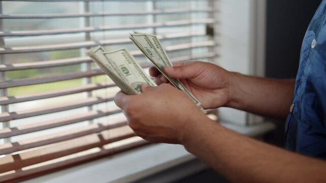 A person carefully counts a stack of bills, surrounded by warm sunlight. The serene atmosphere contrasts with the excitement of handling cash