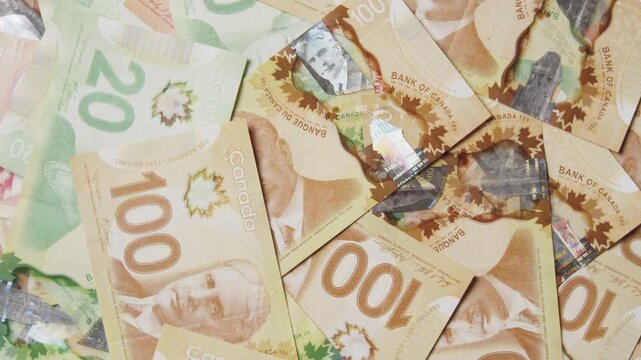 Colorful Canadian banknotes create a beautiful mosaic, showcasing various denominations. Intricate details of the bills draw the eye, revealing their artistic value