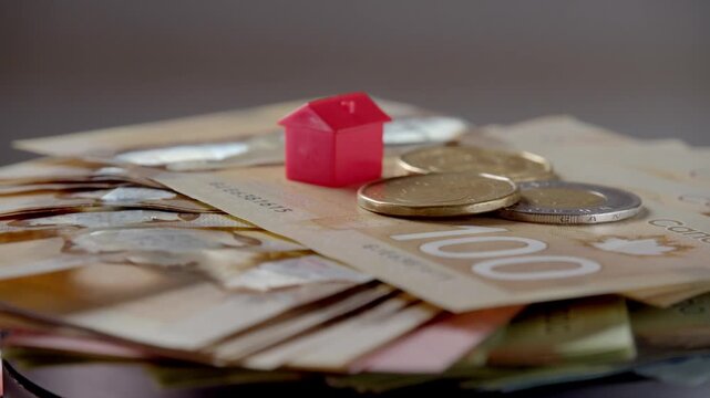 Colorful game pieces come to life on a pile of Australian cash, capturing the beauty of finance. Coins and vibrant houses create a playful atmosphere of wealth