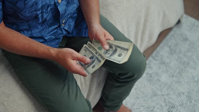 In a comfortable room filled with anticipation, someone counts crisp bills, preparing for a fun weekend getaway filled with joy and exploration