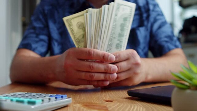 Hands carefully sort and count fresh bills on a wooden table. A quiet atmosphere surrounds thoughtful reflections on a financial choice