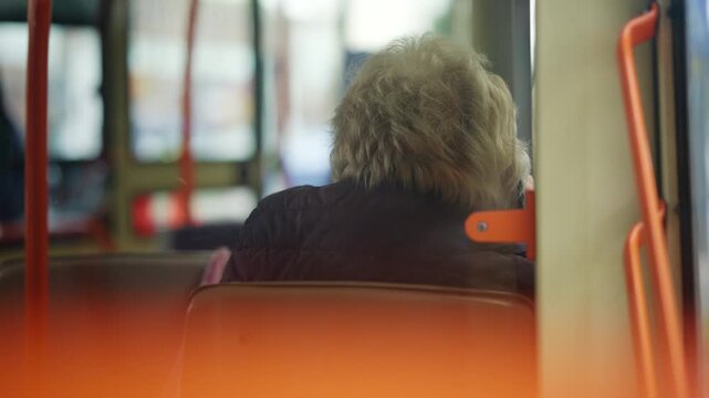 Soft focus interior view of a passenger sitting inside a public transportation vehicle