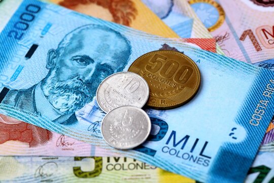 Costa Rican colon money bills and coins on table. Costa Rica cash of CRC currency close up