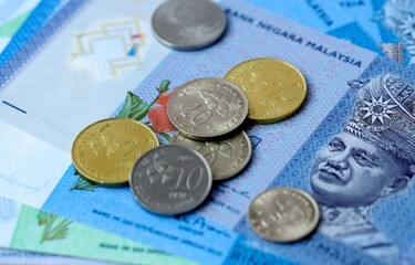 Malaysian ringgit money bills and coins on table. Malaysia cash of MYR currency close up © Larysa