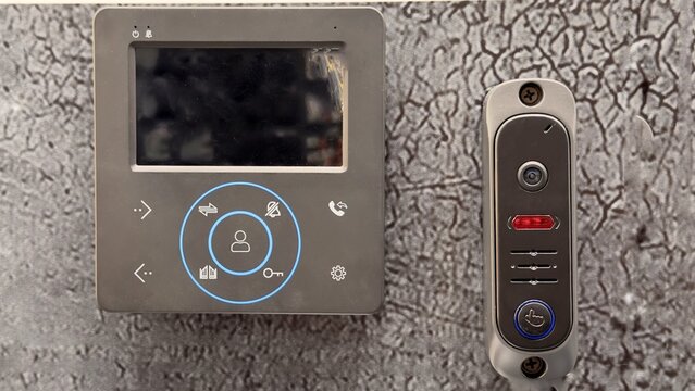 Modern Black Video Intercom System and Smart Outdoor Doorbell Camera on Textured Grey Background