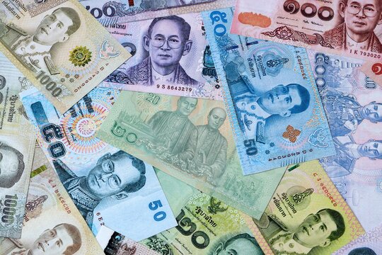 Thai baht money bills in pile on table. Thailand THB currency cash close up