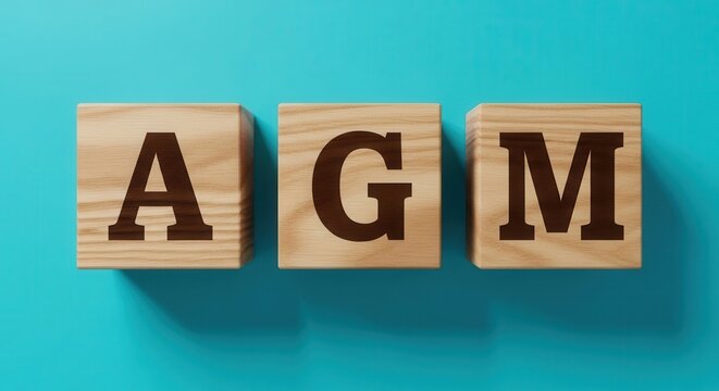 Wooden Letter Blocks Spelling AGM on Vibrant Turquoise Background