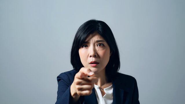 真剣な表情で指をさす女性