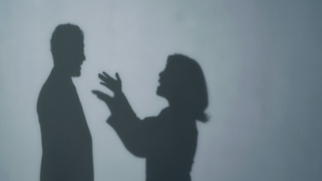 Silhouettes of a man and woman arguing