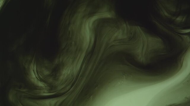 Abstract background of dark green and black ink swirling underwater. Mesmerizing fluid motion creates a moody, smoky organic pattern. Perfect for dramatic overlays.
