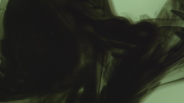 Abstract background of dark green and black ink swirling underwater. Mesmerizing fluid motion creates a moody, smoky organic pattern. Perfect for dramatic overlays.