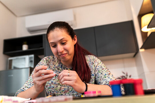 Costumed performer preparing special effects makeup materials at a kitchen table