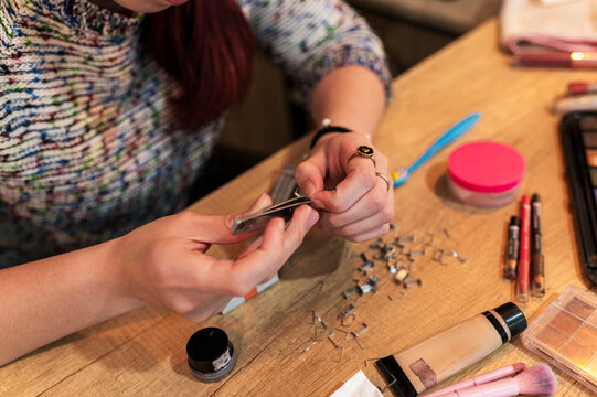 Special effects makeup artist arranging prosthetic supplies on a home studio table