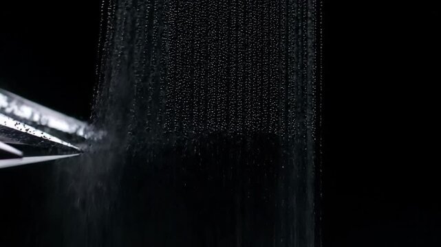 Closeup of a fountain pen writing on a black surface creating a textured line of ink