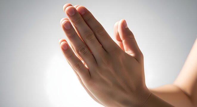 Close up of hands pressed together in prayer with soft shadow gradient