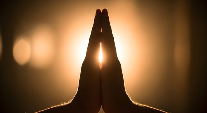 Hands in prayer, bathed in warm light with soft bokeh, symbolizing peace and spirituality