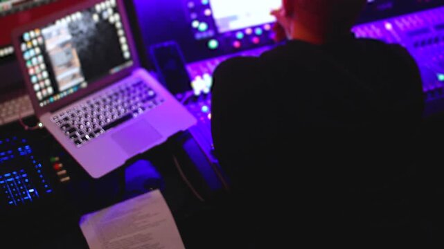 Lighting engineer operator working on mixing console workplace during live event concert on stage show broadcast, light mixer controller panel, sound technician workplace with professional equipment