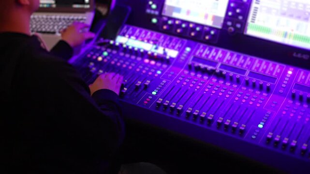 Lighting engineer operator working on mixing console workplace during live event concert on stage show broadcast, light mixer controller panel, sound technician workplace with professional equipment