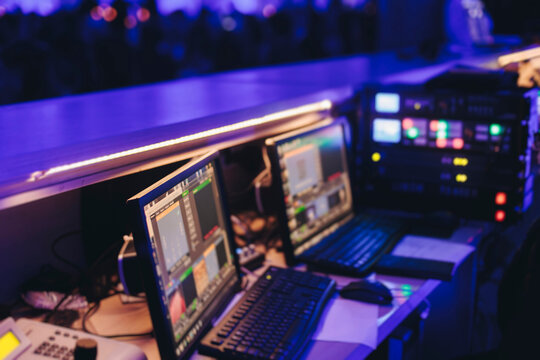 Lighting engineer operator working on mixing console workplace during live event concert on stage show broadcast, light mixer controller panel, sound technician workplace with professional equipment