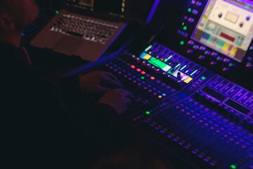 Lighting engineer operator working on mixing console workplace during live event concert on stage show broadcast, light mixer controller panel, sound technician workplace with professional equipment © tsuguliev