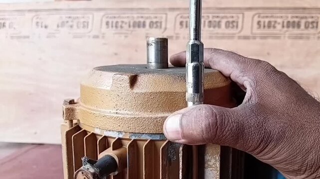 Mechanic Tightening Water Pump Motor Bolts In A Cross Pattern Using A T Handle Box Spanner For Alignment