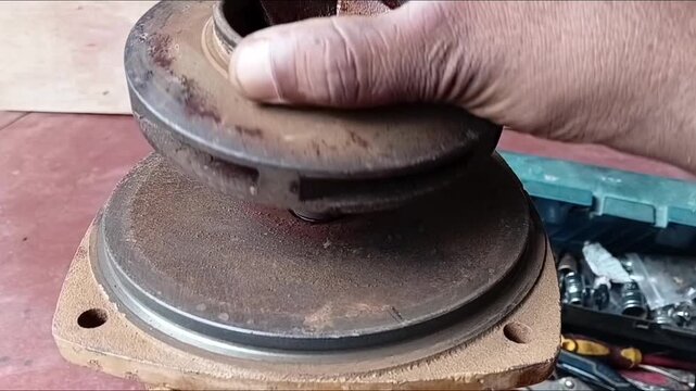 Close Up Of A Mechanic Attaching The Brass Impeller Onto The Rotor Shaft Of A Water Pump