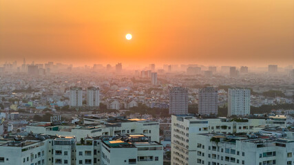 Fototapeta premium Aerial view of Saigon cityscape at morning with misty sky in Southern Vietnam. Urban development texture, transport infrastructure and green parks