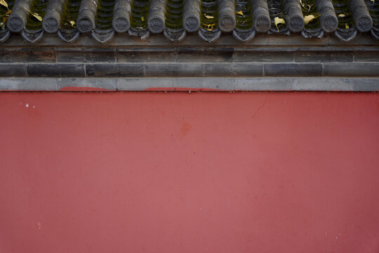 Traditional Chinese red wall with tiled roof in close-up view
