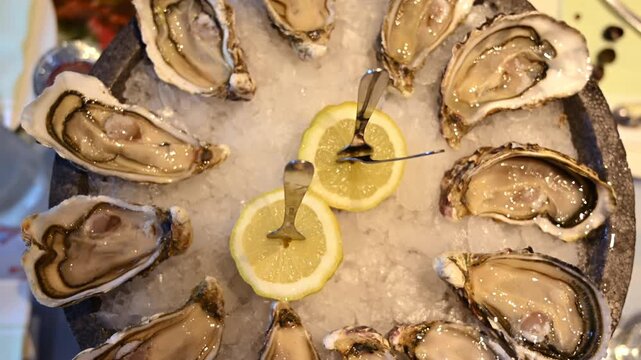 Fresh oysters displayed on crushed ice with sliced lemons in a seafood restaurant setting