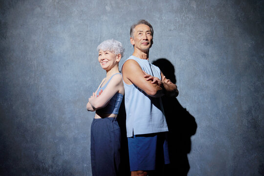 スポーツウェアを着たシニア男性と女性　ポートレート　黒背景