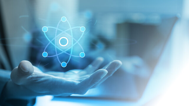 Abstract quantum computing concept with digital atom symbol floating above a hand, representing AI, data processing, advanced algorithms, innovation, and future technology systems.
