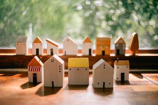 A model house on a wooden table. A concept illustrating the growth of the real estate business. Interest on mortgages and land. Annual property tax.