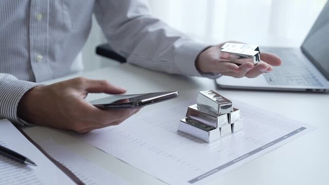 Asian businessman trading silver on smartphone