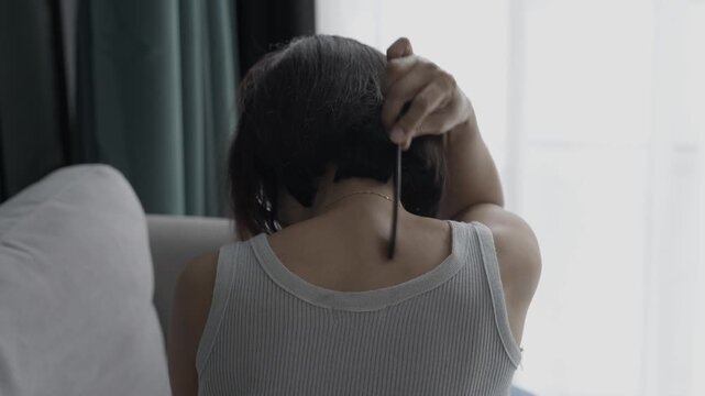 Asian mature woman using gua sha massage her neck