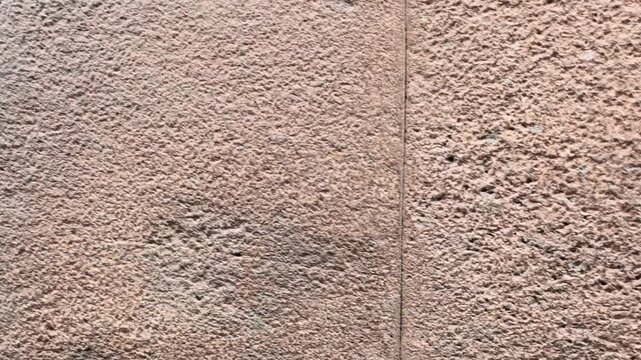 Cusco, Peru - 20 June 2024. Detail of an Inca masonry wall showing a carved drainage hole between stone blocks, with mineral and moisture staining beneath the opening.