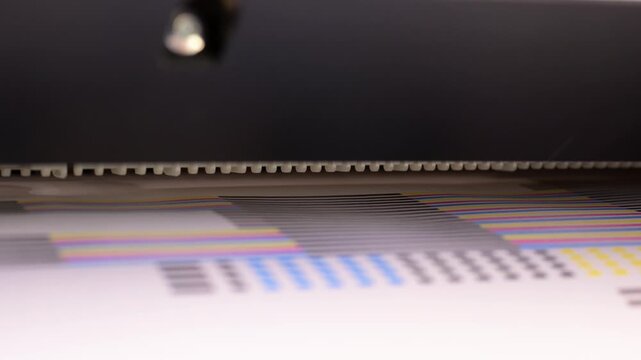 Close-up of a professional inkjet printer head calibration process with CMYK color test pattern