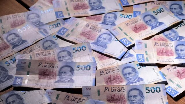 Mexican currency backdrop. Background of several 500 Mexican peso banknotes scattered on a surface