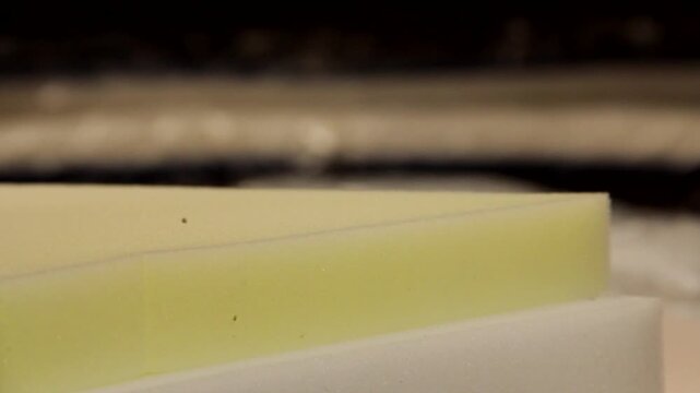 Industrial Foam Sheets with Different Colors and Densities. Close Up of Layered Foam Sheets in Production Facility. Colored Foam Panels Used in Furniture and Mattress Manufacturing. 