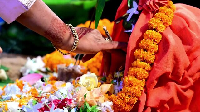 Close-up footage of bride and groom hands participating in traditional Hindu wedding rituals during a marriage ceremony in India. The scene captures sacred customs, ceremonial offerings