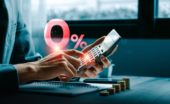 Interest rate calculation concept with person using calculator beside percent symbol and coin stacks showing financial planning loan cost savings growth investment and business finance strategy