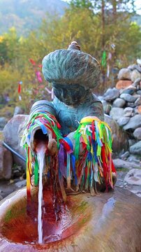 A spring of beneficial mineral water in the form of a sculpture of a Buryat boy. Arshan, Buryatia, Kyngyrga River