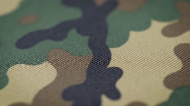 Close-up of fabric in a camouflage pattern with green, brown, and black