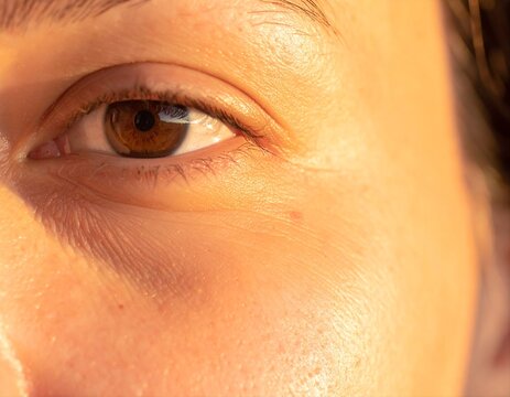 Close up human eye skin texture macro warm sunlight natural face