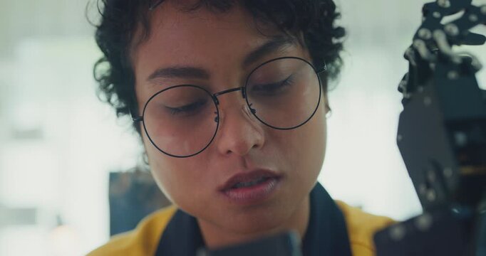 Close-up young Black female engineer coding AI robot arm in modern laboratory. Robotics, artificial intelligence, technology, stem, future, innovation, diversity, automation, machine learning concept.