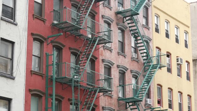 New York City urban residential buildings architecture, Manhattan classic street, United States of America. Typical red brick house in NYC, real estate property in USA. Fire escape metallic ladder.